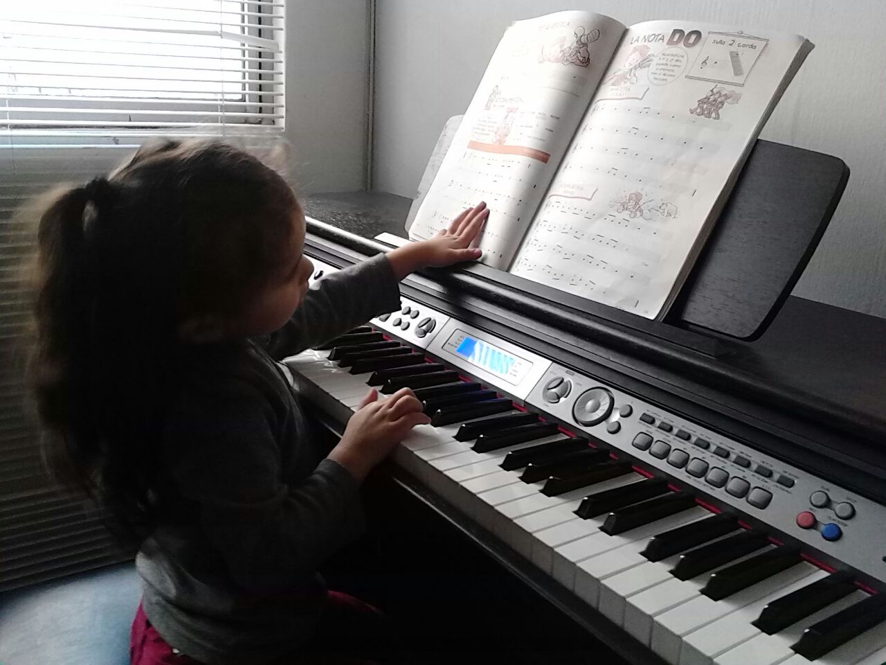 Niña aprendiendo piano en la Academia Integral de Artes